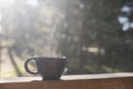 Beautiful morning mood on terrace of log house in forest with closeup of unique handmade coffee mug