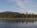 Beautiful morning over lake Sjabatjakjaure with view on Parte Fjallstuga STF mountain cabin, green hills and birch trees. Sweden