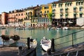 Beautiful morning in Peschiera del Garda town. Colorful houses, architecture view with boats. Little town harbour Royalty Free Stock Photo