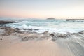 Beautiful morning on the sandy beach. Long exposure at the sea. Milky sunrise in haze and fog. Corralejo, Canary Islands, Spain