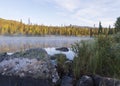 Beautiful morning sunrise over lake Sjabatjakjaure with haze mist in Sweden Lapland nature. Mountains, birch trees, spruce forest Royalty Free Stock Photo