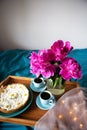 Beautiful morning Vanilla cheesecake, coffee, blue cups, pink peonies in a glass vase
