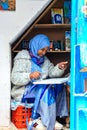 A beautiful Moroccan girl, a Muslim, street artist paints a picture with a brush in a small workshop