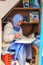 A beautiful Moroccan girl, a Muslim, street artist paints a picture with a brush in a small workshop