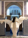 Beautiful Moroccan Girl Waving her white mantle in Rich interior of Picturesque Dar Si Said Riyad in Marrakech
