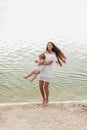 Beautiful mother with baby daughter are having fun and playing near the lake. The concept of summer holiday. Mother`s, baby`s da Royalty Free Stock Photo