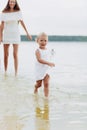 Beautiful mother with baby daughter are having fun and playing near the lake. The concept of summer holiday. Mother`s Royalty Free Stock Photo