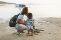 Beautiful mother and baby outdoors Mum and her child together enjoying seaview. Back view. Woman with backpack and cute Royalty Free Stock Photo