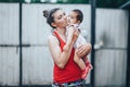 Beautiful Mother And Baby outdoors on the yard of house. Beauty Mum and her baby Child one year old playing in yard together. Mom Royalty Free Stock Photo