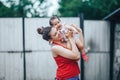 Beautiful Mother And Baby outdoors on the yard of house. Beauty Mum and her baby Child one year old playing in yard together. Mom Royalty Free Stock Photo