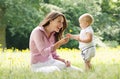 Beautiful mother with baby playing in the park Royalty Free Stock Photo