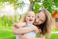 Beautiful mother with cute little baby boy having fun outdoors. Portrait of mom with fun child smiling in green summer Royalty Free Stock Photo