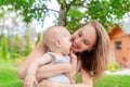 Beautiful mother with cute little baby boy having fun outdoors. Portrait of mom with fun child smiling in green summer garden. Royalty Free Stock Photo