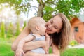 Beautiful mother with cute little baby boy having fun outdoors. Portrait of mom with fun child smiling in green summer garden. Royalty Free Stock Photo