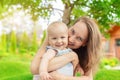 Beautiful mother with cute little baby boy having fun outdoors. Portrait of mom with fun child smiling in green summer Royalty Free Stock Photo