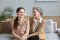 Beautiful mother and daughter. Cheerful young woman is embracing her middle aged mother in living room. Family portrait Royalty Free Stock Photo