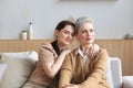 Beautiful mother and daughter. Cheerful young woman is embracing her middle aged mother in living room. Family portrait. Royalty Free Stock Photo