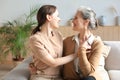 Beautiful mother and daughter. Cheerful young woman is embracing her middle aged mother in living room. Family portrait Royalty Free Stock Photo