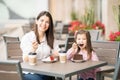 Beautiful mother and daughter having cake at cafe Royalty Free Stock Photo