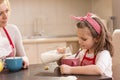 Little girl pouring milk into a cereal bowl Royalty Free Stock Photo