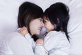 Beautiful mother and daughter lying on bed Royalty Free Stock Photo