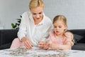 beautiful mother and daughter playing with jigsaw puzzle Royalty Free Stock Photo
