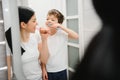 Beautiful mother and happy son brushing teeth near mirror in bathroom Royalty Free Stock Photo