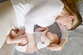 Beautiful mother and her cute little baby are sleeping at home,hugging in bed. Child safety and protection, co-sleeping Royalty Free Stock Photo