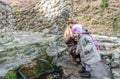 Beautiful mother with her daughter Baby drink water from the holy spring that flows from the rock among the vegetation Royalty Free Stock Photo