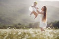 Beautiful mother and her daughter playing in spring flower field Royalty Free Stock Photo