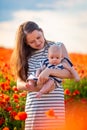 Beautiful mother and her daughter in spring poppy flower field, Czech republic Royalty Free Stock Photo