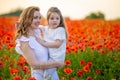 Beautiful mother and her daughter in spring poppy flower field, Czech republic Royalty Free Stock Photo