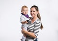 Beautiful mother holding baby daughter in her arms. Studio shot. Royalty Free Stock Photo