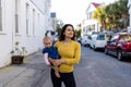 Beautiful mother holding her cute baby in peaceful neighborhood Royalty Free Stock Photo