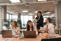 Beautiful mother is holding her son. Infant baby is in the office where group of people are working together Royalty Free Stock Photo