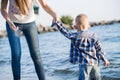 Beautiful mother holds a small child on the shore by the sea