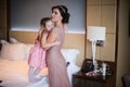 Beautiful mother hugs daughter in the bedroom