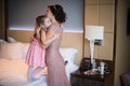 Beautiful mother hugs daughter in the bedroom