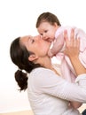 Beautiful mother kissing baby girl hug on white Royalty Free Stock Photo