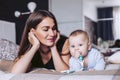 Beautiful mother looks at the child lying on a bed