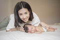 Beautiful mother is playing with her newborn baby in the bedroom Royalty Free Stock Photo