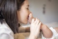 Beautiful mother is playing with her newborn baby in the bedroom Royalty Free Stock Photo