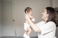 Beautiful mother is playing with her newborn baby in the bedroom Royalty Free Stock Photo