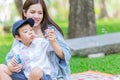 Beautiful mother playing with her son enjoy holiday outdoor green park background Royalty Free Stock Photo