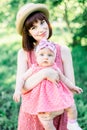 Beautiful Mother with the straw hat And her little daughter outdoors family look in in a pink dress . Outdoor Portrait Royalty Free Stock Photo