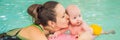 Beautiful mother teaching cute baby girl how to swim in a swimming pool. Child having fun in water with mom BANNER, LONG Royalty Free Stock Photo