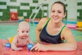 Beautiful mother teaching cute baby girl how to swim in a swimming pool. Child having fun in water with mom Royalty Free Stock Photo