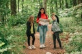 Beautiful mother with two kids are walking through forest and planning a hiking adventure Royalty Free Stock Photo