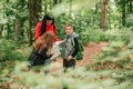 Beautiful mother with two kids are walking through forest, using a map and planning a hiking adventure Royalty Free Stock Photo