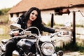 Beautiful motorcycle brunette woman with a classic motorcycle c